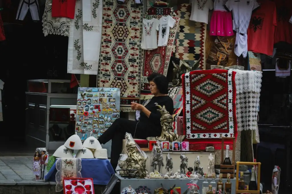 Merchant Crocheting among Displayed Souvenirs