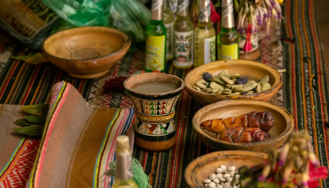 Vibrant display of traditional Peruvian food, drink and handicrafts on a colorful table in Cusco.