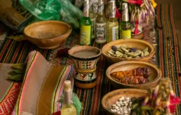 Vibrant display of traditional Peruvian food, drink and handicrafts on a colorful table in Cusco.