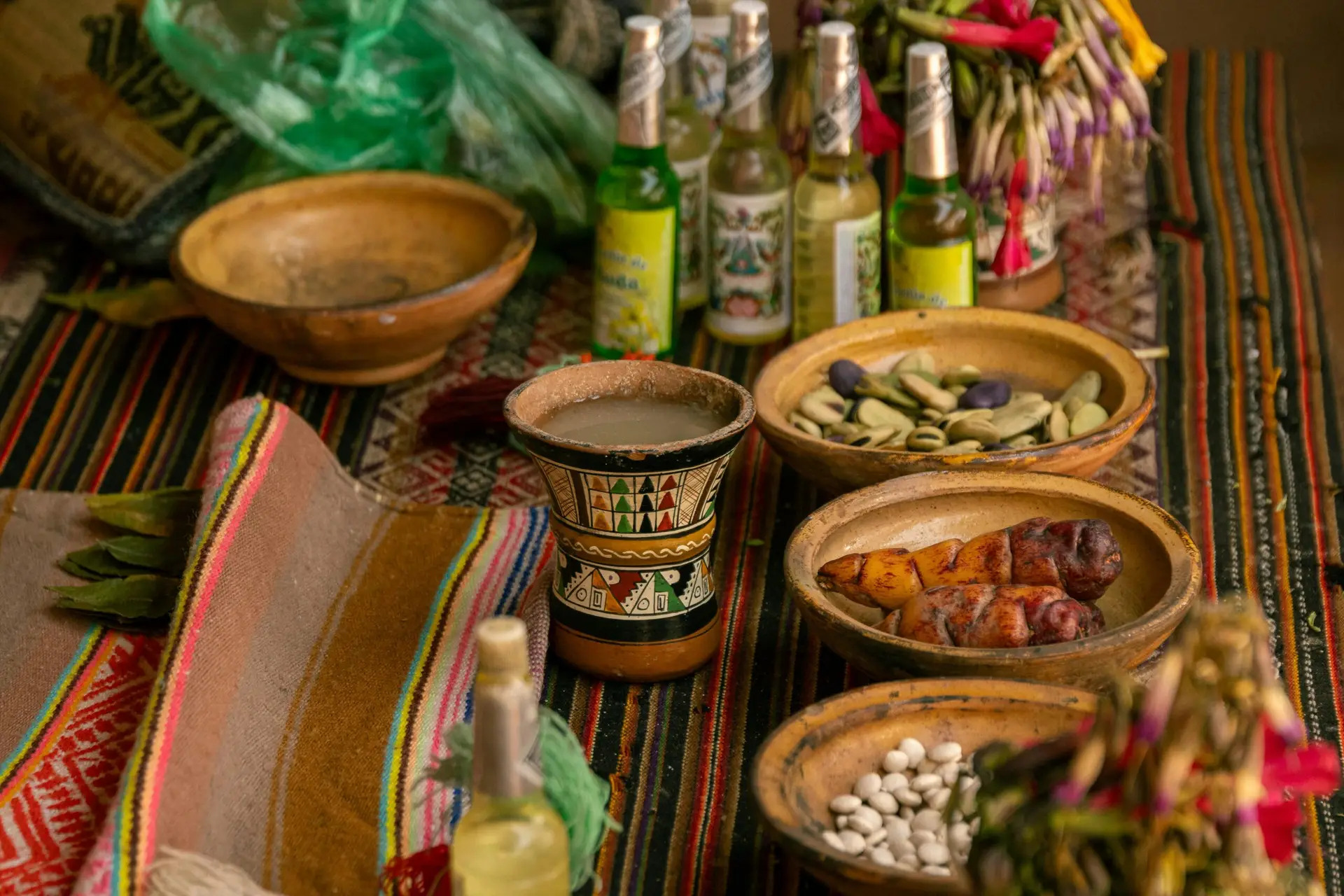 Vibrant display of traditional Peruvian food, drink and handicrafts on a colorful table in Cusco.